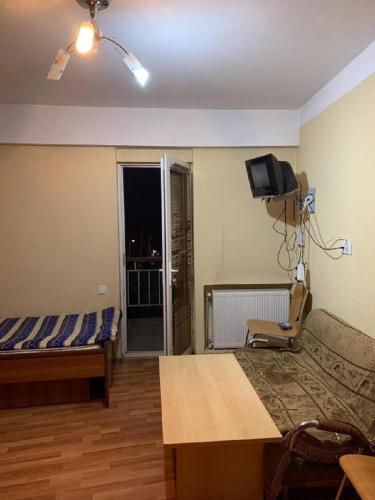 a room with a bed and a couch and a tv at axis in Kʼumlistsʼikhe