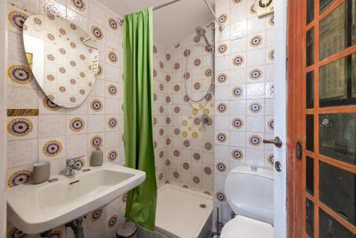 Un baño con lavabo, inodoro y ducha. en Spaziosa Villa con piscina, BBQ e campi da tennis, en Casal Palocco
