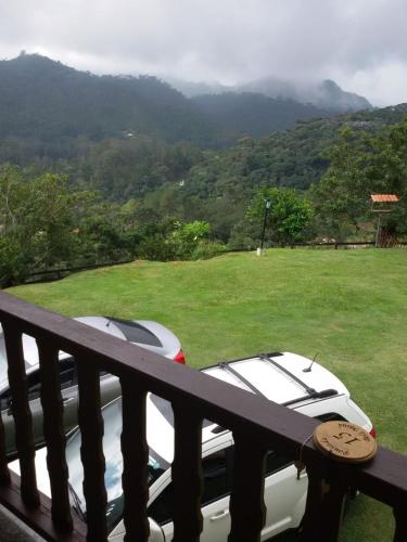 two cars parked on a balcony with a view of a mountain at Pousada Bela Mauá in Itatiaia
