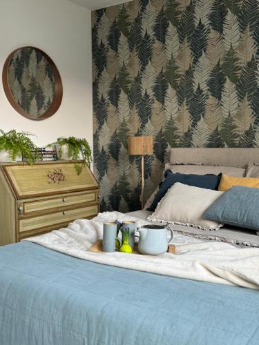 a bed with a tray with cups and mugs on it at Apartament nad jeziorem in Barlinek