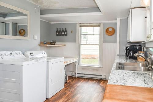 a kitchen with white appliances and a sink and a window at Walk to State park, 6bed,Hot tub & Game room in Watkins Glen