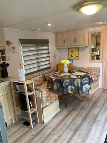 un salon avec un canapé et une table dans l'établissement Birch Breeze - 2 bedroom mobile home at Camping Les Amiaux, à Saint-Jean-de-Monts