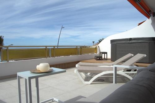 a balcony with two chairs and a table on a roof at Seafront Playa La Arena in Puerto de Santiago