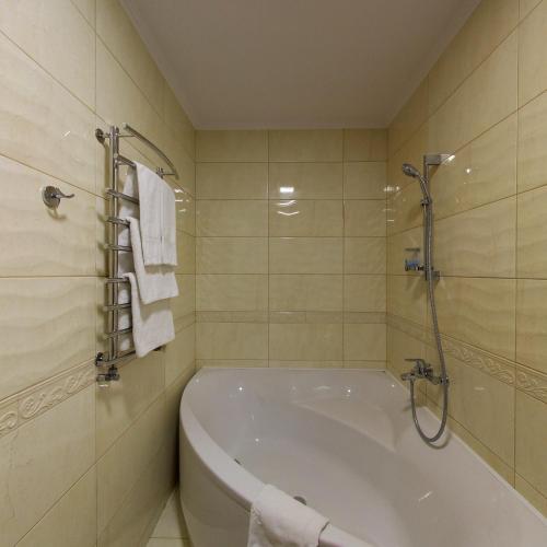a bathroom with a tub and a shower with towels at Argo in Lviv