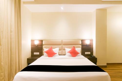 a bedroom with a large white bed with red pillows at Super Collection O Starlight in Kānpur