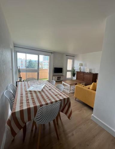 un salon avec une table et un canapé dans l'établissement Appartement de la Famille Chat, au Mans