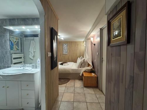 La salle de bains est pourvue d'un lavabo et d'un lit dans la chambre. dans l'établissement Chambres d'hôtes salles de bain intégrée et entrée privée , parking gratuit, à Sarlat-la-Canéda