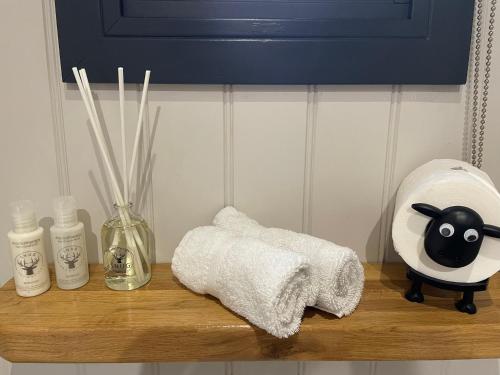 a shelf with a towel and a toy animal on it at Springwood Shepherd Huts Glamping York in York