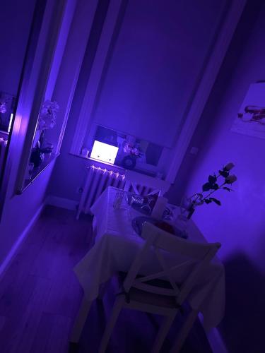 a purple room with a table and chairs in it at La Pause Roséeenne in Rousies