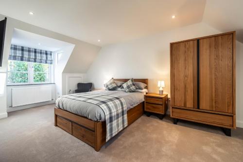 a bedroom with a bed and a dresser and a window at Holly Tree Cottage in Dornoch