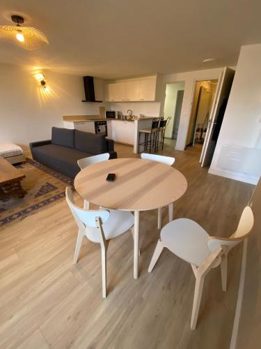 une table et des chaises en bois dans un salon dans l'établissement Appartement dans maison proche mer, à Ver-sur-Mer