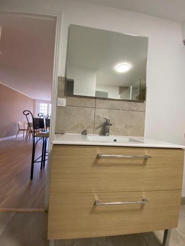 une salle de bain avec un lavabo et un miroir dans l'établissement Appartement dans maison proche mer, à Ver-sur-Mer