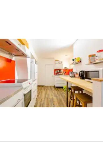 une cuisine avec des comptoirs blancs et une table à l'intérieur dans l'établissement Washington, à Chambéry