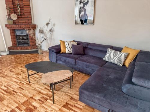 a living room with a blue couch and a fireplace at Pie Jūras in Saulkrasti