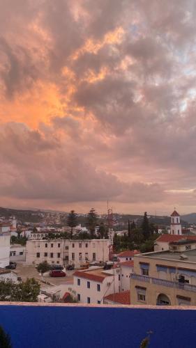 a view of a city under a cloudy sky at Hotel Al Manar in Chefchaouene