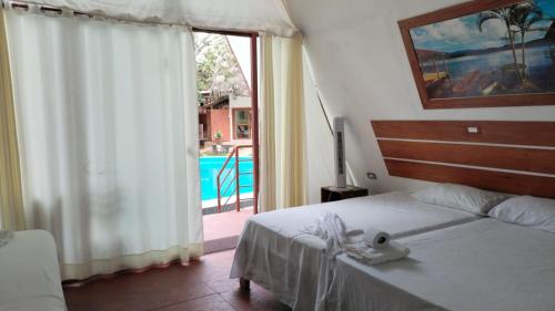 a bedroom with a bed and a door to a pool at Cabaña del Lago Sauce in Sauce