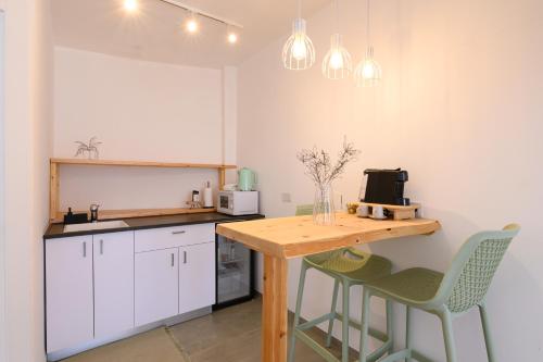 a kitchen with a wooden table and two chairs at נקודה בנוף - וילה פרטית in Had Nes