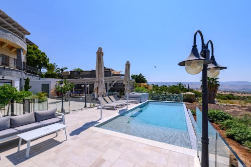 a villa with a swimming pool and a house at נקודה בנוף - וילה פרטית in Had Nes