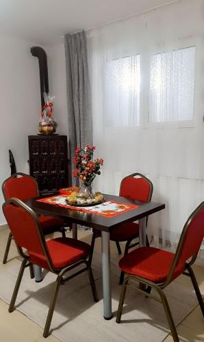 a dining room table with chairs and a vase of flowers on it at ANK - HOME i PRESIDENT - NIK in Telcişor