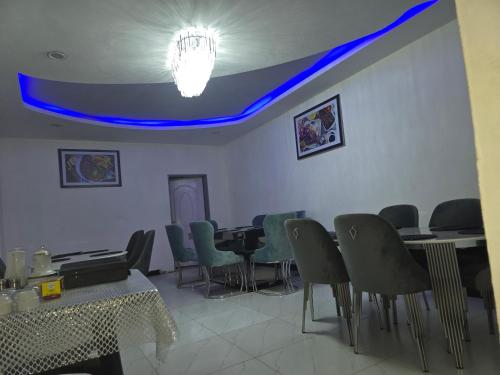 a waiting room with chairs and tables and a blue ceiling at Zuba waterfall executive Lodge in Simon Mwansa Kapwepwe International Airport