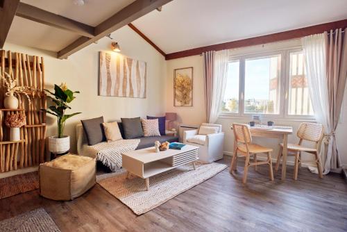 un salon avec un canapé et une table dans l'établissement Les Appartements du Bord de Mer, à Trouville-sur-Mer