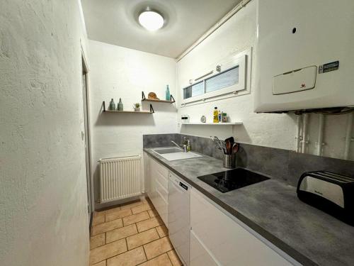 une cuisine avec un évier et un plan de travail dans l'établissement Appartement avec parking, à Chartres
