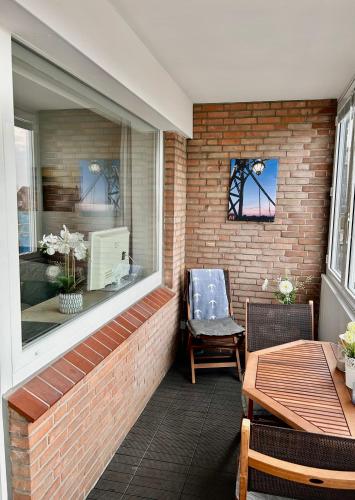 a patio with a window and a table and a chair at Wilhelms Havenkoje - gemütliches Innenstadtappartment in Wilhelmshaven
