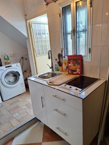 a kitchen with a sink and a washing machine at Ikigai House in Seville