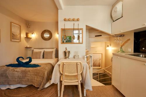 une chambre avec un lit, une table et des chaises dans l'établissement Les Appartements du Bord de Mer, à Trouville-sur-Mer