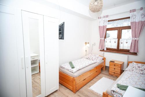 a bedroom with two beds and a window at Hostinec pod úbočou in Valaská