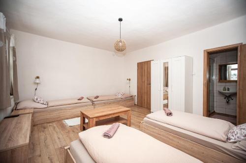 a living room with two beds and a table at Hostinec pod úbočou in Valaská