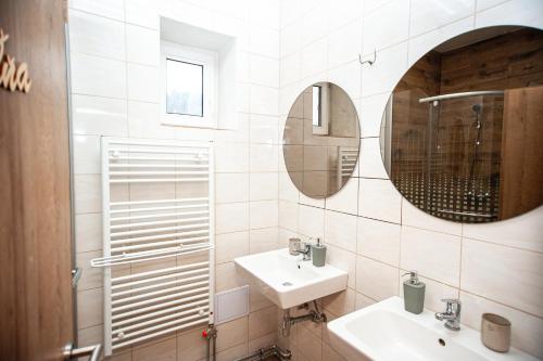 a white bathroom with a sink and a mirror at Hostinec pod úbočou in Valaská