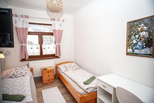 a bedroom with two beds and a window at Hostinec pod úbočou in Valaská