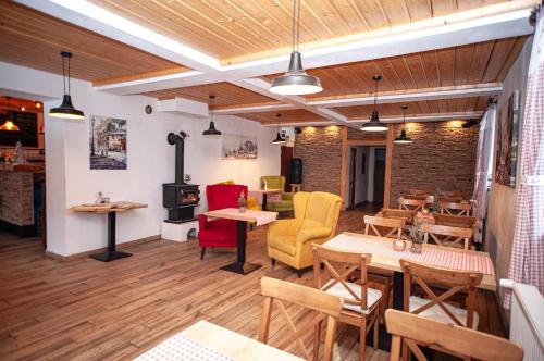 a restaurant with wooden floors and tables and chairs at Hostinec pod úbočou in Valaská