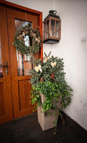 a door with a wreath and a basket of plants at Hostinec pod úbočou in Valaská