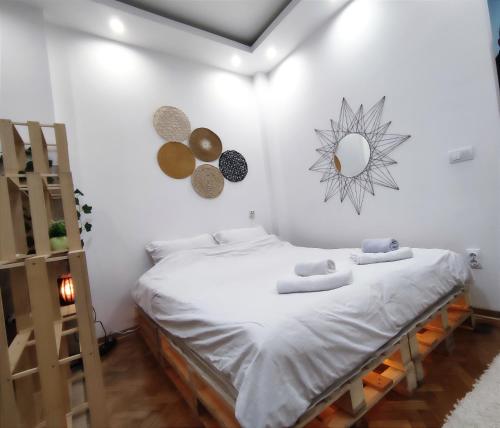Un dormitorio con dos camas y un espejo en la pared. en Boho-Style Apartment in the city center, en Belgrado
