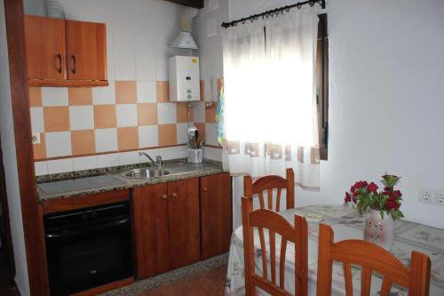 cocina con fregadero y mesa con sillas en Apartamento Fatima, en Conil de la Frontera