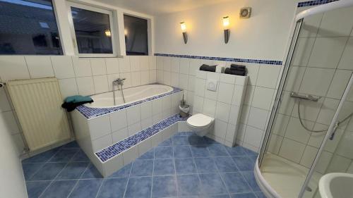 a bathroom with a tub and a toilet and a shower at Ferienwohnung Monteurzimmer Zülpich Bauernhof in Zülpich