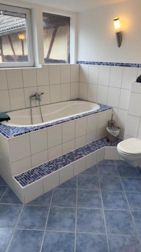 a bathroom with a tub and a toilet at Ferienwohnung Monteurzimmer Zülpich Bauernhof in Zülpich