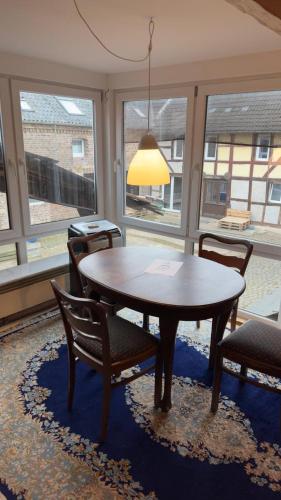 a dining room with a table and chairs and windows at Ferienwohnung Monteurzimmer Zülpich Bauernhof in Zülpich