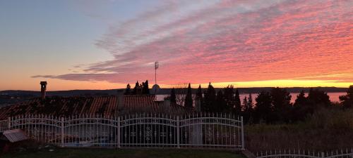 a sunset with a white fence in front of a building at Guest house Vila Luka 2 in Portorož