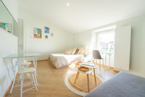 une chambre avec un lit, une table et des chaises dans l'établissement Appartement lumineux & calme en centre ville, à La Rochelle