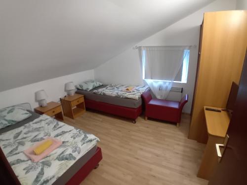 a small room with two beds and a chair at Holiday home Ivano in Korenica