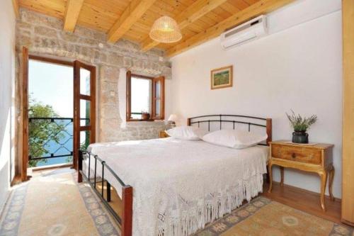 a bedroom with a large bed and a window at Stone house in Brela