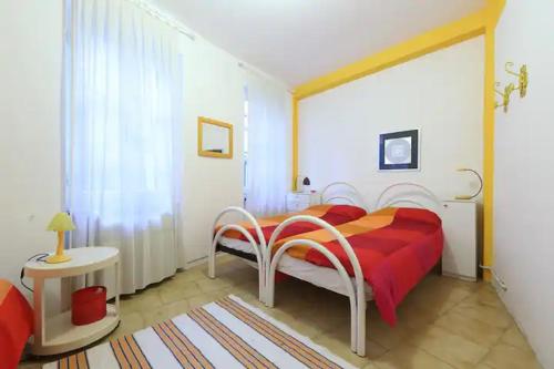 een slaapkamer met een rood bed en een rode deken bij Appartamento Basuetta alle Cinque Terre con AC in Monterosso al Mare