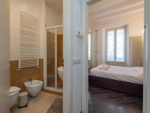 bagno con letto, lavandino e servizi igienici di I Host Apartment - Montenero 58 a Milano