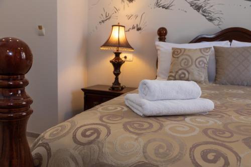 a bed with a lamp and two towels on it at Capital Luxury Rooms Split in Split