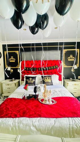 a bedroom with a bed with black and white balloons at House of Royalty in Gqeberha