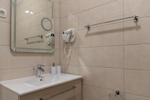 a bathroom with a sink and a mirror at Capital Luxury Rooms Split in Split