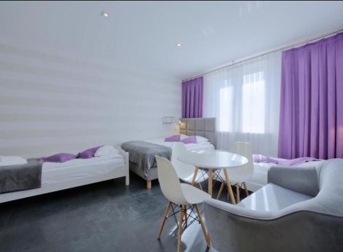 a room with three beds and a table and chairs at Willa Marion in Karpacz